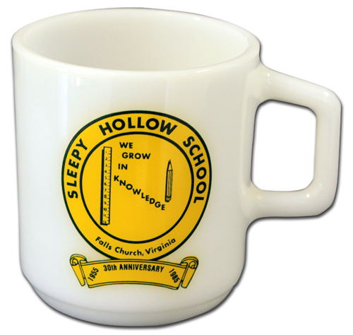 Photograph of a white coffee mug with a yellow seal that reads Sleepy Hollow School, Falls Church, Virginia. We Grow in Knowledge.